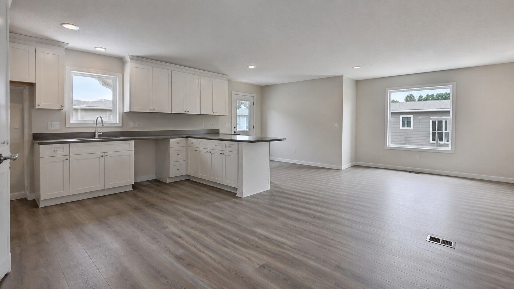 Interior of an empty kitchen and open living area in a factory-built home